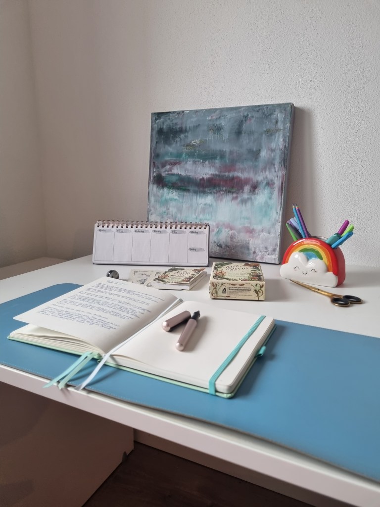 Offenes Notizbuch beim Journaling auf einem Schreibtisch mit Stiften und Tarotkarten